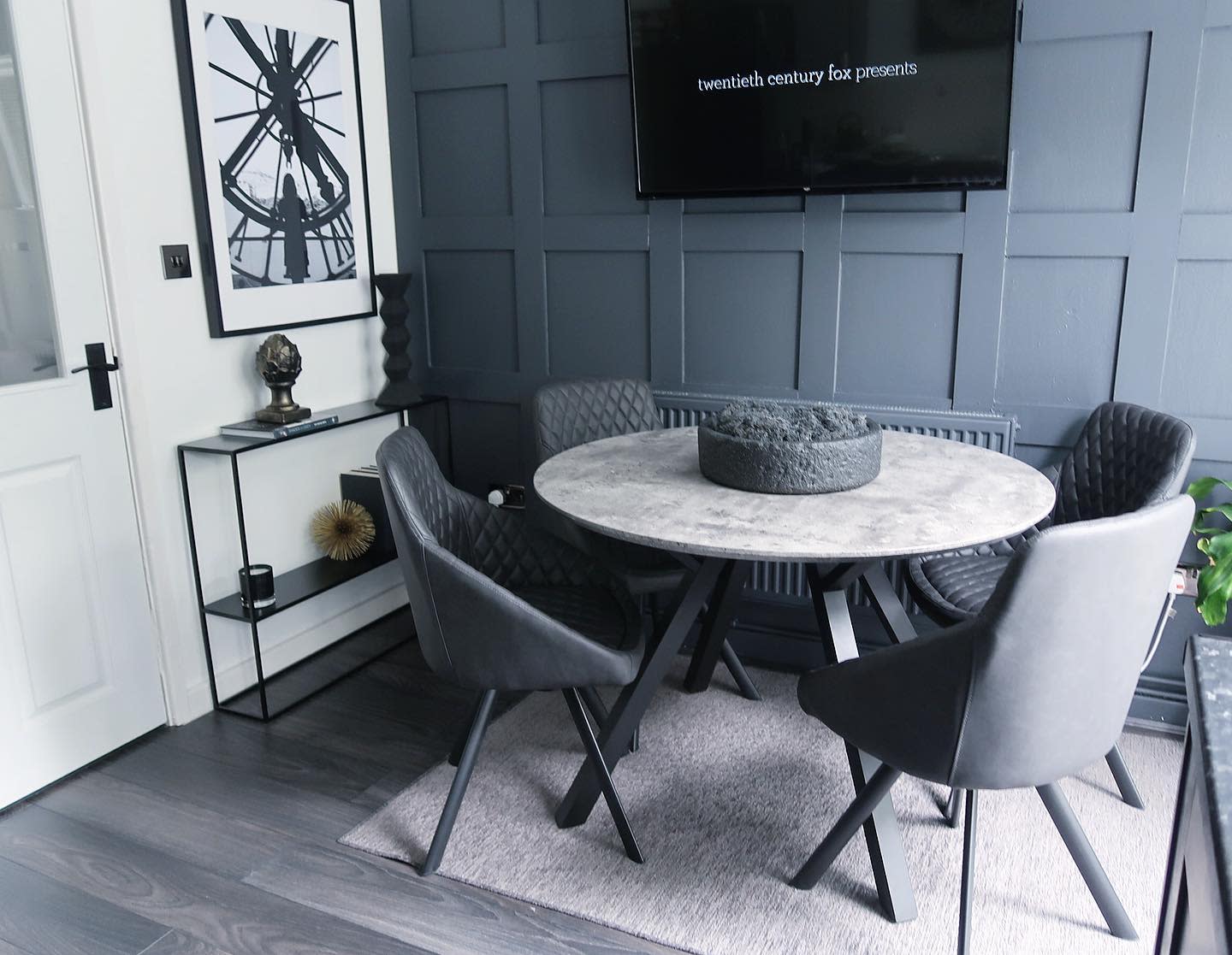 gray feature wall dining table four chairs floor rug 